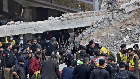 Security officials and rescue workers search bodies at the site of suicide bombing, in Peshawar. (AP)