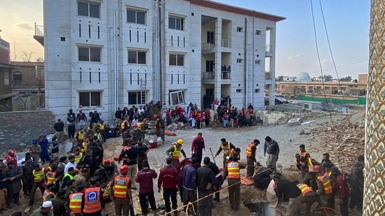 Security officials and rescue workers search bodies at the site of suicide bombing in Peshawar.(AP)