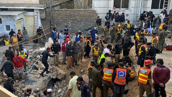 Security officials and rescue workers search bodies at the site of suicide bombing, in Peshawar, Pakistan, Monday, Jan. 30, 2023. A suicide bomber struck Monday inside a mosque in the northwestern Pakistani city of Peshawar, killing multiple people and wounding scores of worshippers, officials said. (AP Photo/Zubair Khan)
