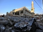 People visit the site of Monday's suicide bombing after authorities finished the rescue operation, in Peshawar, Pakistan.