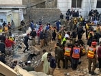 Security officials and rescue workers search bodies at the site of suicide bombing, in Peshawar, Pakistan.