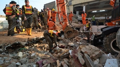 Security officials and rescue workers conduct an operation to clear the rubble and search for bodies at the site of Monday's suicide bombing in Peshawar. (AP)