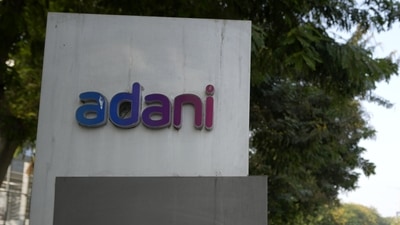 Vehicles move past a signage near the entrance of Adani Corporate House in Ahmedabad, (AP) Vehicles move past a signage near the entrance of Adani Corporate House in Ahmedabad, (AP)