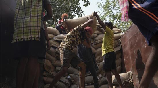 Workers unload rice bags from a truck at civil supplies godown in Hyderabad. (AP)