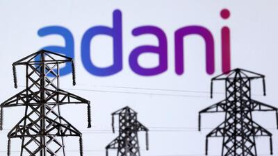 Electric power transmission pylon miniatures and Adani Green Energy logo are seen in this illustration (REUTERS File) Electric power transmission pylon miniatures and Adani Green Energy logo are seen in this illustration (REUTERS File)