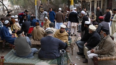 People gather outside the house of a victim, who was killed in mosque suicide blast inside a police headquarters, in Peshawar on February 1. (AFP)