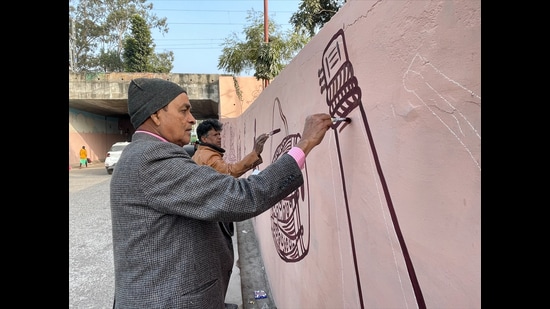 Artists giving final touch to a Kathak painting near a wall on the chowk area of Lucknow. (HT Photo)