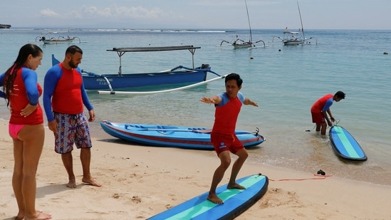 FILE PHOTO: An instructor teaches surfing to tourists in Nusa Dua, Bali, Indonesia, November 17, 2022.REUTERS/Willy Kurniawan/File Photo(REUTERS)