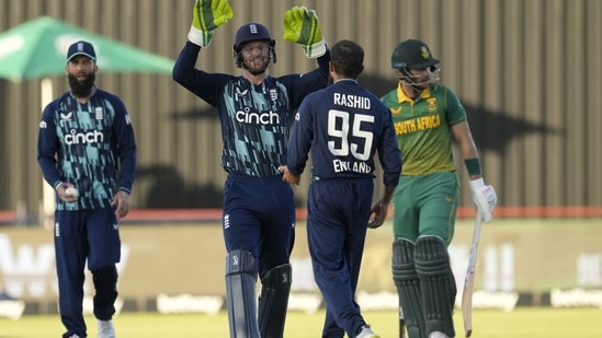 England's captain Jos Buttler, second left, celebrates with bowler Adil Rashid, second right, for dismissing South Africa's batsman Reeza Hendricks, right, for 52 runs during the third One-Day International cricket match between South Africa and England at the Kimberley Oval in Kimberley, South Africa, Wednesday, Feb. 1, 2023. (AP Photo/Themba Hadebe)(AP)