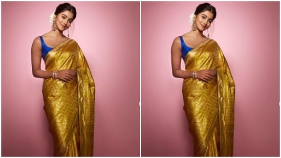 Pooja decked up in a yellow saree and teamed it with a contrasting blue sleeveless blouse, and accessorised her look in golden jewellery. (Instagram/@hegdepooja)