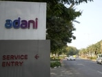 Vehicles move past a signage near the entrance of Adani Corporate House in Ahmedabad,(AP) Vehicles move past a signage near the entrance of Adani Corporate House in Ahmedabad,(AP)