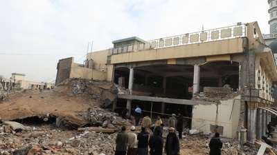 Peshawar Mosque Blast: People stand amid the rubble, following a suicide blast in a mosque in Peshawar. (Reuters)