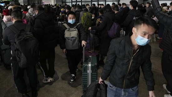 Covid In China: Travelers with their luggage arrive at a departure hall to catch their trains at the West Railway Station in Beijing.(AP)