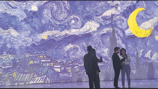 Giant screens turn a makeshift shelter at the World Trade Center, Mumbai, into a room full of van Goghs. Here, visitors against a backdrop of The Starry Night (Zara Murao)