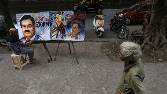 An artist Sagar Kambli paints Indian businessman Gautam Adani, depicting the ongoing Adani group- hidenburg research row.(AP)