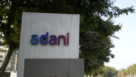 Vehicles move past a signage near the entrance of Adani Corporate House in Ahmedabad,(AP)