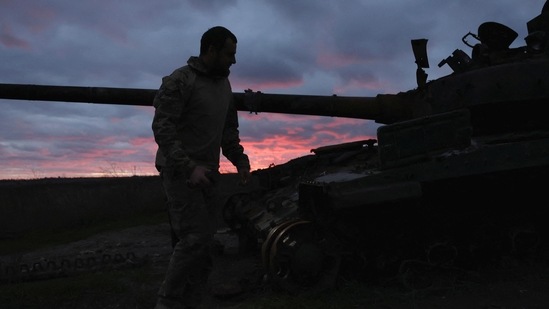 Russia-Ukraine War: A Ukrainian serviceman walks near a destroyed tank at sunset, as Russia's invasion of Ukraine continues, near Izium, Ukraine.(Reuters)