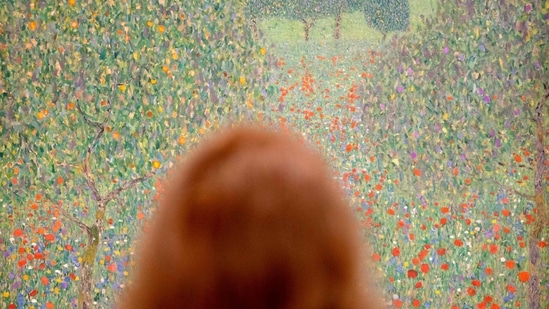 A woman looks at the painting 'Field of Poppies' (1907) by Austrian painter Gustav Klimt (1862-1918), during a preview of the exhibition 'Klimt inspired by Van Gogh, Rodin, Matisse' at The Belvedere Museum in Vienna, Austria on February 2, 2023. - A canvas with a turbulent history by the most famous of Austrian painters, Gustav Klimt, will be shown to the public from February 3 for the first time in nearly sixty years in his country of origin. ((Photo by JOE KLAMAR / AFP))
