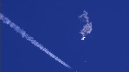 In this photo provided by Chad Fish, the remnants of a large balloon drift above the Atlantic Ocean, just off the coast of South Carolina, with a fighter jet and its contrail seen below it, on Saturday. (AP)