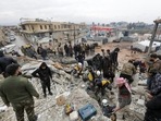 People gather as rescuers search for survivors under the rubble, following an earthquake, in rebel-held town of Jandaris, Syria. 