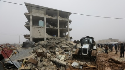 People gather as rescuers search for survivors under the rubble, following an earthquake, in rebel-held town of Jandaris, Syria. (REUTERS)
