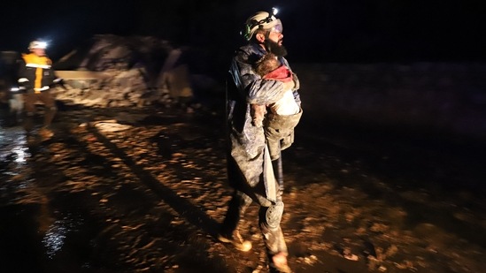 A member of the Syrian civil defense, known as the White Helmets, seen carrying a child rescued from the rubble following an earthquake in the town of Zardana, a northwestern Syrian Idlib province, early on February 6. The earthquake hit while people were asleep, and has resulted in over 1900 deaths. (Abdulaziz Ketaz / AFP)