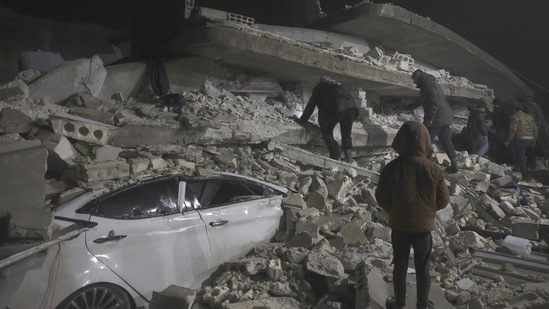 Syrian citizens search through the wreckage of a collapsed building, in Azmarin town, in Idlib province, north Syria, on February 6. Buildings were reported collapsed in a wide area extending from Syria’s cities of Aleppo and Hama to Turkey’s Diyarbakir, more than 330 kilometers to the northeast.(Ghaith Alsayed / AP)