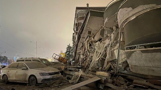 Damaged vehicles seen parked in front of a collapsed building following the devastating earthquake, in Diyarbakir, southeastern Turkey, on February 6, People trying to leave the quake-stricken regions caused traffic jams, hampering the efforts of emergency teams trying to reach the affected areas. Authorities urged residents not to take to the roads.(Depo Photos via AP)