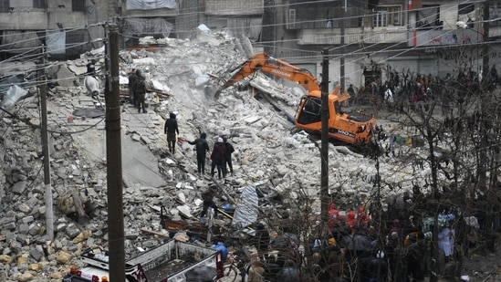 People watch as rescue teams look for survivors under the rubble of a collapsed building after the earthquake in the regime-controlled northern Syrian city of Aleppo, on February 6. The region sits on top of major fault lines and is frequently shaken by earthquakes. Some 18,000 were killed in a similarly powerful earthquake that hit northwest Turkey in 1999.(AFP)