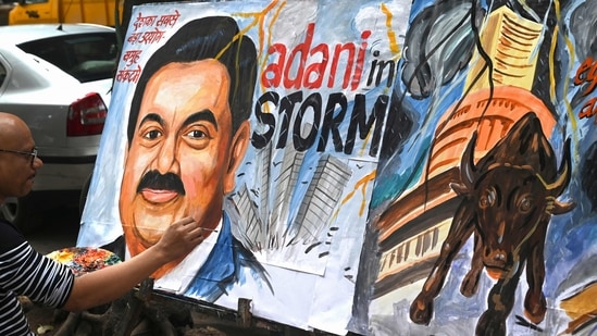 Art school teacher Sagar Kambli gives final touches to a painting of Indian businessman Gautam Adani highlighting the ongoing crisis of the Adani Group in Mumbai.(AFP)