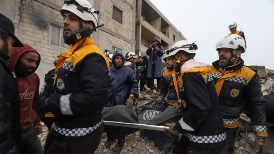 Members of the Syrian civil defence, known as the White Helmets transport a casualty pulled from the rubble following the earthquake in northwestern Syrian Idlib province.(AFP)