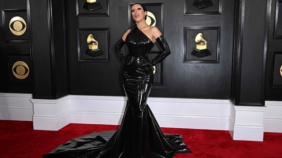 US rapper Doja Cat chose a black latex gown by Versace to walk the red carpet at the 65th Grammy Awards. Though her look was quite tame compared to the last few fashion outings she pulled off, the ensemble's figure-hugging silhouette and gorgeous structure added Doja to our best-dressed list. She glammed up the fierce look with matching black hoop earrings, bold winged eyeliner, a metallic lip, and a stunning pixie cut.&nbsp;(AFP)