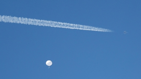A jet flies by a suspected Chinese spy balloon as it floats off the coast in Surfside Beach, South Carolina, (REUTERS)