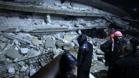 Residents search for victims and survivors amidst the rubble of a building that collapsed after the massive 7.9 magnitude earthquake.(AFP)