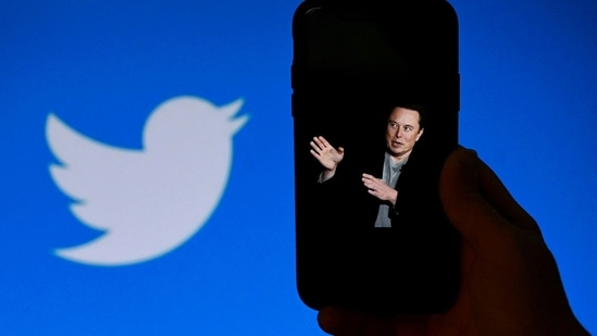 An illustration photo shows a phone screen displaying a photo of Elon Musk with the Twitter logo shown in the background.(AFP)