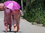 Women hold an umbrella as they walk along a street on a hot summer day in Srinagar. (AFP) Women hold an umbrella as they walk along a street on a hot summer day in Srinagar. (AFP)