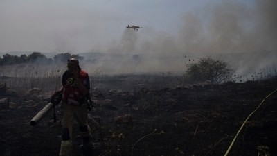 A firefighter works to extinguish a fire following an attack from Lebanese Hezbollah group in the Israeli-controlled Golan Heights, Thursday, July 4, 2024. (AP) A firefighter works to extinguish a fire following an attack from Lebanese Hezbollah group in the Israeli-controlled Golan Heights, Thursday, July 4, 2024. (AP)