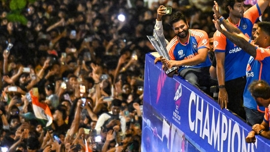 Indian cricket captain Rohit Sharma holds the trophy as he greets fans.(AFP)