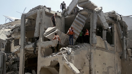 Palestinian rescuers work to evacuate casualties from a residential building hit by Israeli strikes which destroyed shops at Gaza's Old City market, amid the Israel-Hamas conflict. (Reuters)