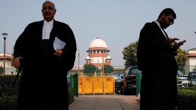 A lawyer looks into his mobile phone as another walks past, in front of the Supreme Court in New Delhi (REUTERS FILE PHOTO) A lawyer looks into his mobile phone as another walks past, in front of the Supreme Court in New Delhi (REUTERS FILE PHOTO)