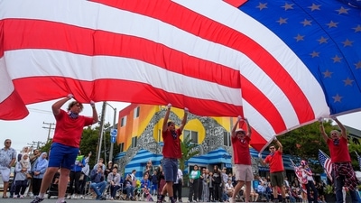 People hold a giant flag to celebrate Independence Day at the 17th annual Santa Monica 4th of July parade in Santa Monica, Calif., on Thursday, July 4, 2024. (AP/Damian Dovarganes) People hold a giant flag to celebrate Independence Day at the 17th annual Santa Monica 4th of July parade in Santa Monica, Calif., on Thursday, July 4, 2024. (AP/Damian Dovarganes)