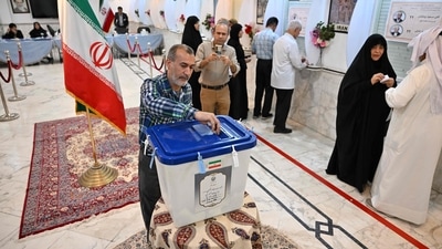 Iranian vote during the presidential election at the Iranian embassy in Kuwait City on July 5, 2024. Polls opened on July 5 for Iran's runoff presidential election, the interior ministry said, pitting reformist candidate Masoud Pezeshkian against ultraconservative Saeed Jalili in the race to succeed Ebrahim Raisi, who died in a May helicopter crash. (Photo by Yasser AL ZAYYAT / AFP) Iranian vote during the presidential election at the Iranian embassy in Kuwait City on July 5, 2024. Polls opened on July 5 for Iran's runoff presidential election, the interior ministry said, pitting reformist candidate Masoud Pezeshkian against ultraconservative Saeed Jalili in the race to succeed Ebrahim Raisi, who died in a May helicopter crash. (Photo by Yasser AL ZAYYAT / AFP)