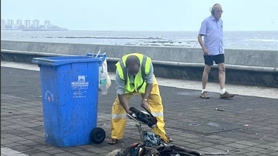 A BMC worker cleans up the detritus of Thursday's celebrations on Marine Drive. HT Photo A BMC worker cleans up the detritus of Thursday's celebrations on Marine Drive. HT Photo