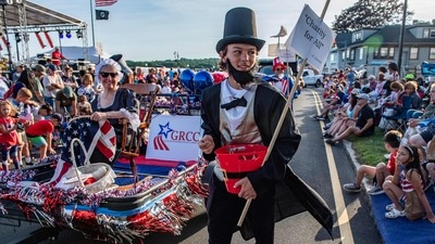 A person dressed as President Abraham Lincoln gives out candy as a woman dressed as Betsy Ross sits in a float and holds a US flag during the Fishtown Horribles Parade, ahead of Independence Day, in Gloucester, Massachusetts, on July 3, 2024. The parade is part of the city's July 4th celebrations. (AFP/Joseph Prezioso) A person dressed as President Abraham Lincoln gives out candy as a woman dressed as Betsy Ross sits in a float and holds a US flag during the Fishtown Horribles Parade, ahead of Independence Day, in Gloucester, Massachusetts, on July 3, 2024. The parade is part of the city's July 4th celebrations. (AFP/Joseph Prezioso)