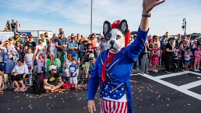 A person promoting pet adoptions and wearing an Uncle Sam dog costume waves as they participate in the Fishtown Horribles Parade ahead of Independence Day in Gloucester, Massachusetts, on July 3, 2024. The parade is part of the city's July 4th celebrations. (AFP/Joseph Prezioso) A person promoting pet adoptions and wearing an Uncle Sam dog costume waves as they participate in the Fishtown Horribles Parade ahead of Independence Day in Gloucester, Massachusetts, on July 3, 2024. The parade is part of the city's July 4th celebrations. (AFP/Joseph Prezioso)