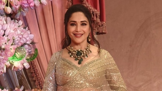 Madhuri Dixit looks golden in a beautiful saree with a massive necklace.