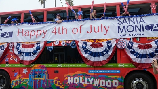 People ride on a 100% Electric Drive bus, manufactured by the Chinese automaker BYD, to celebrate Independence Day at the Santa Monica 4th of July parade in Santa Monica, Calif., on Thursday, July 4, 2024.&nbsp;(AP/Damian Dovarganes)