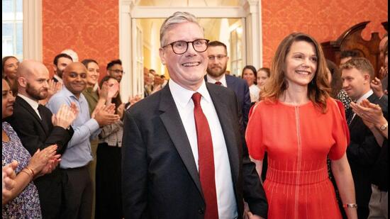 Prime Minister Sir Keir Starmer and his wife Victoria Starmer are clapped in by staff as they enter his official residence at No 10 Downing Street for the first time in London, Britain, on Friday. (REUTERS)