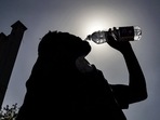 A passenger drinking water is silhouetted against the sun on a hot summer day at Jalandhar Cantonment railway station in Jalandhar on June 11, 2024 amid heatwave. (113 degrees Fahrenheit). (Photo by Shammi MEHRA / AFP)(AFP) A passenger drinking water is silhouetted against the sun on a hot summer day at Jalandhar Cantonment railway station in Jalandhar on June 11, 2024 amid heatwave. (113 degrees Fahrenheit). (Photo by Shammi MEHRA / AFP)(AFP)