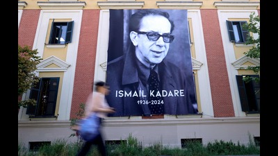 A woman walks by a banner with a portrait of renowned Albanian writer Ismail Kadare on the second day of national mourning following his death on July 1 2024, in Tirana, on July 3, 2024. (Photo by ADNAN BECI / AFP) (AFP) A woman walks by a banner with a portrait of renowned Albanian writer Ismail Kadare on the second day of national mourning following his death on July 1 2024, in Tirana, on July 3, 2024. (Photo by ADNAN BECI / AFP) (AFP)